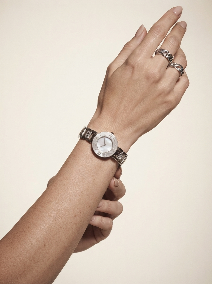 Close-up of model wearing steel roman numeral watch with bracelet
