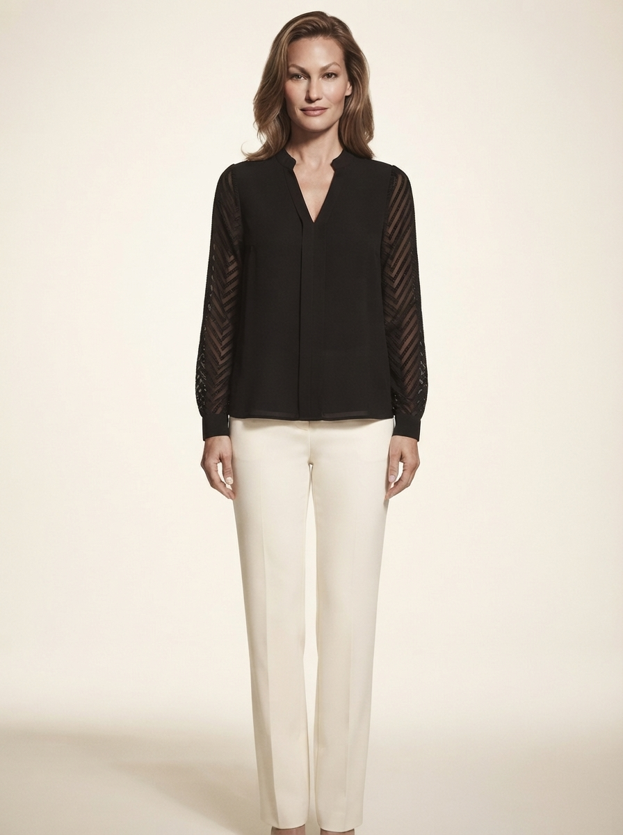 Model wearing black chiffon blouse with sheer textured sleeves