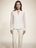 Model wearing white chiffon blouse with sheer textured sleeves