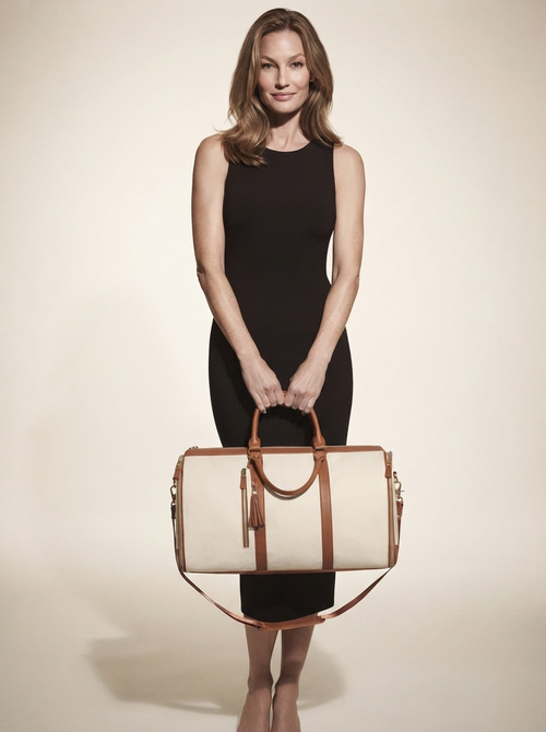 Model carrying beige foldable vegan leather duffle bag