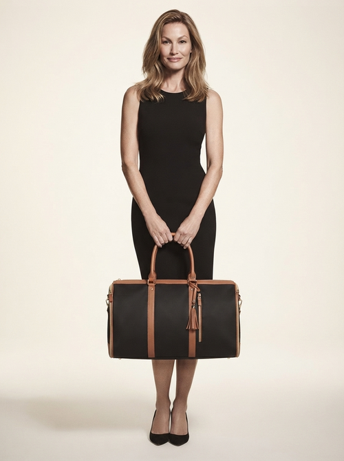 Model carrying black foldable vegan leather duffle bag